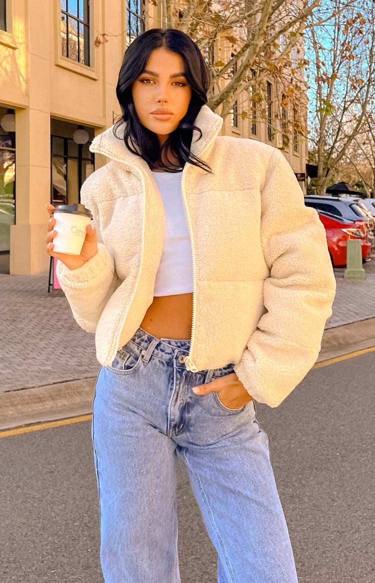 Cropped cream teddy puffer jacket with a high stand collar and visible zipper, showing its soft texture