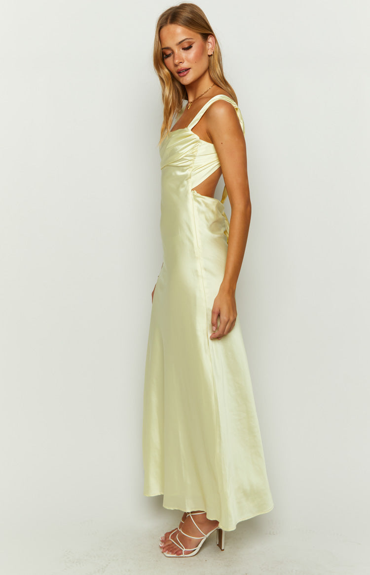 Side profile of a yellow satin maxi dress with ruched bust and side waist cutouts