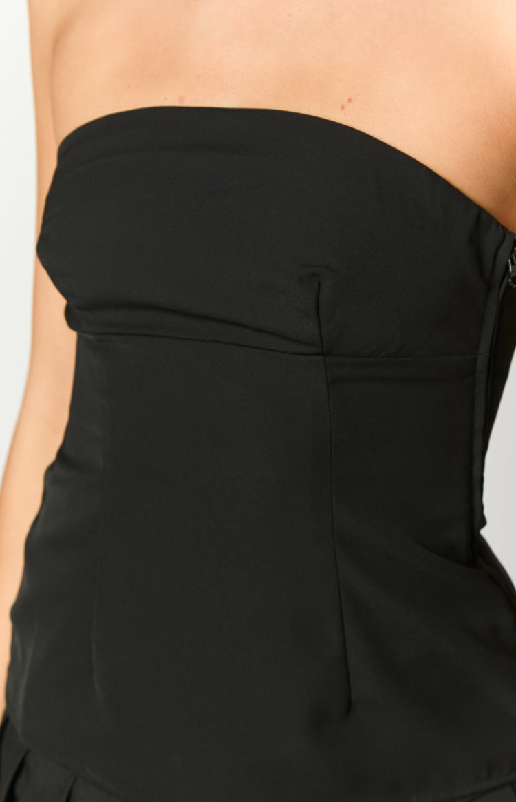 Detail shot of the black strapless top's structured bodice, subtle bust dart, and side zipper closure