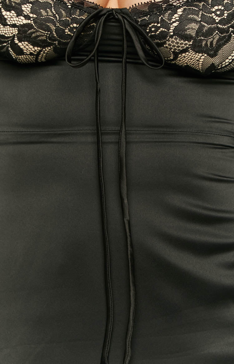 Close-up of the black lace bust with beige lining and a central drawstring tie, above the smooth black satin fabric