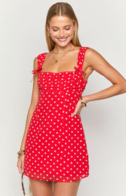 Red polka dot mini dress with square neckline, shoulder ties, and ruched bodice