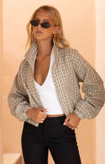 Front view of a beige plaid funnel neck jacket, partially unzipped, with elasticated cuffs and hem