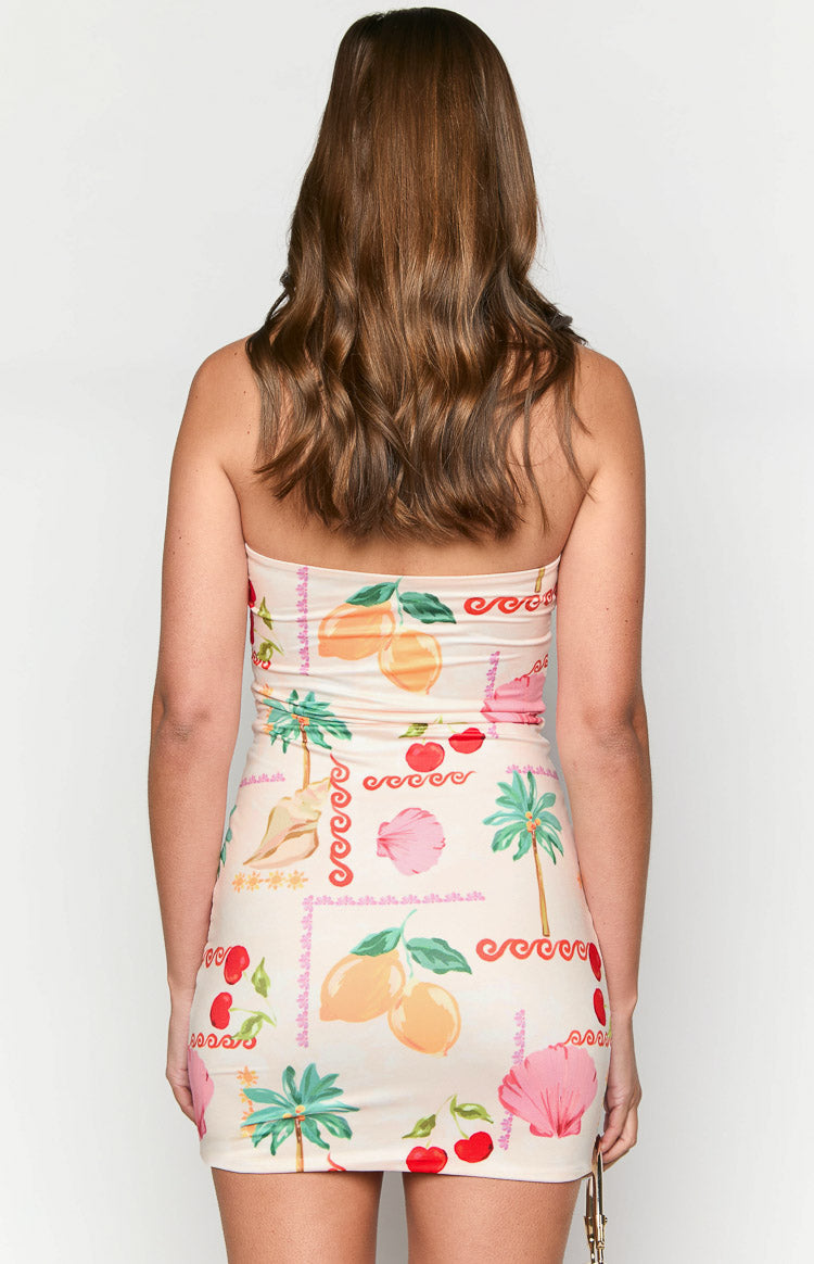 Rear view of a cream strapless mini dress with a colourful resort pattern of lemons, cherries, palm trees, and shells