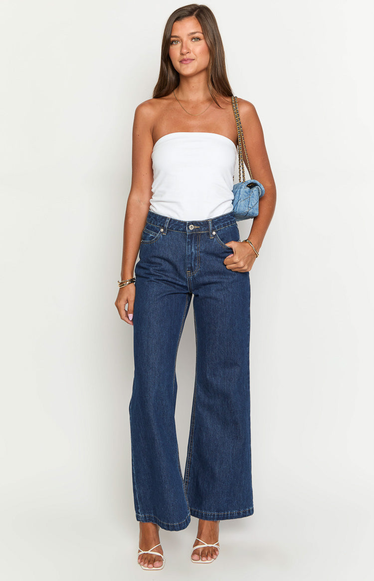 Front view of dark blue high-waisted denim flare jeans with front pockets and a wide leg