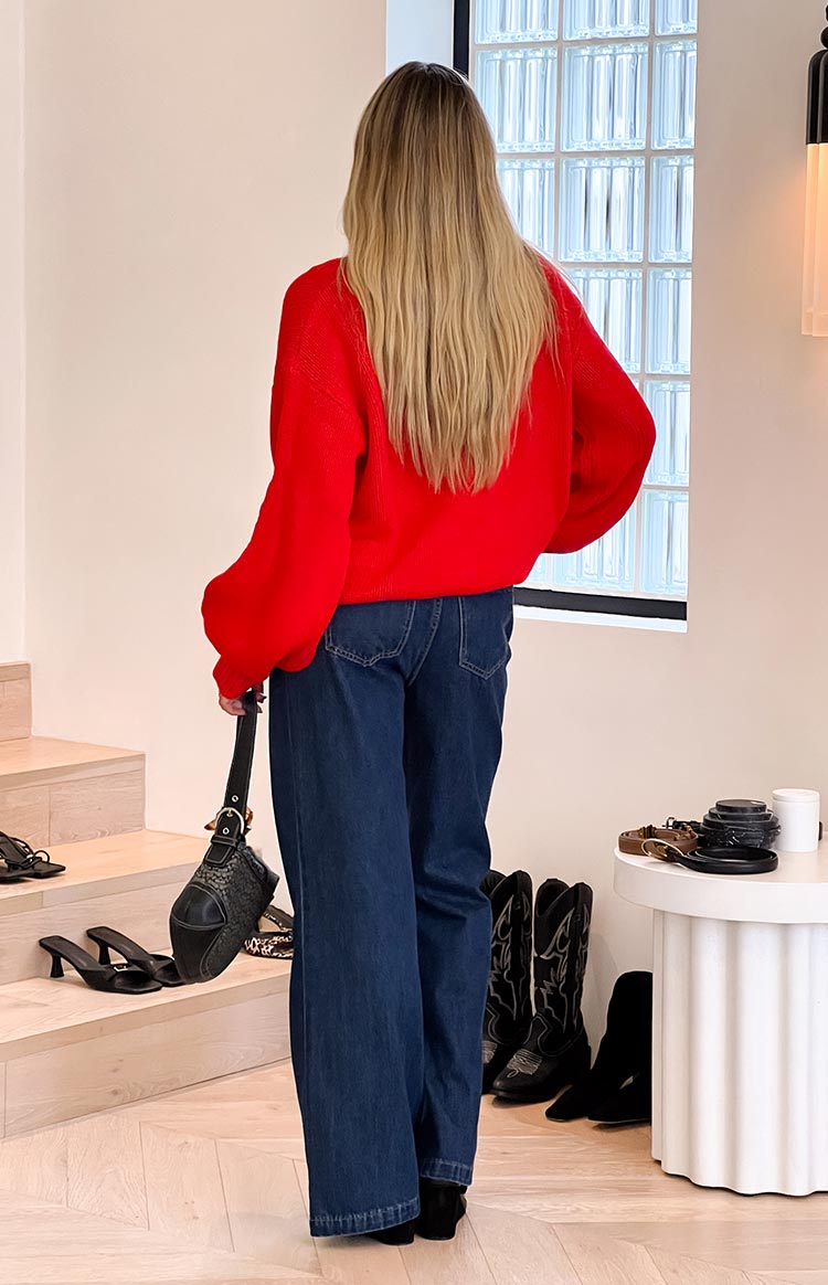 Rear view of dark blue denim flare jeans showing the back pockets and wide flared hem