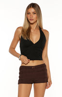 Model wearing brown textured micro shorts with a studded belt and black halter top a chic look for a Summer Festival