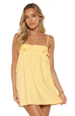 Front view of a yellow mini dress with a shirred bust, ruffled top edge, and drawstring ties