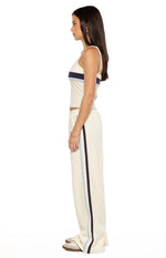 Side view of a white singlet with thin straps and horizontal dark blue and light blue contrast stripes
