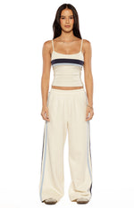 Front view of off-white wide-leg pants with elasticated waist and navy and light blue side stripes