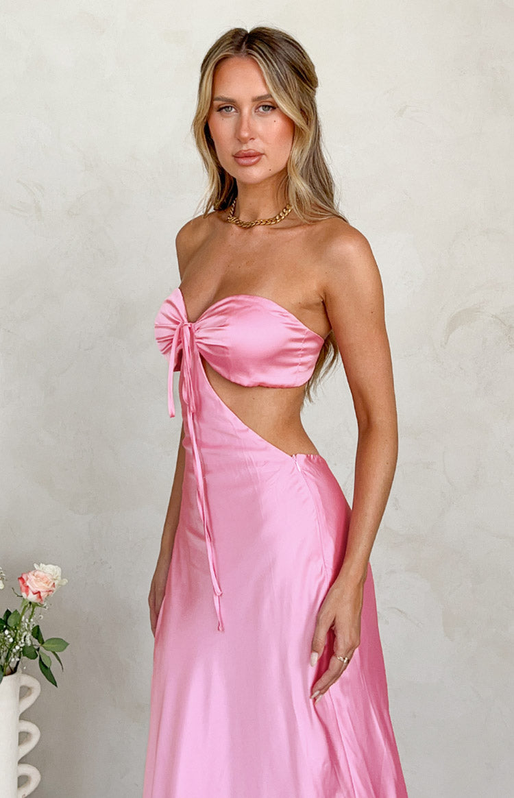 Front-side view of the pink satin strapless maxi dress highlighting the central tie detail and diagonal side cutout