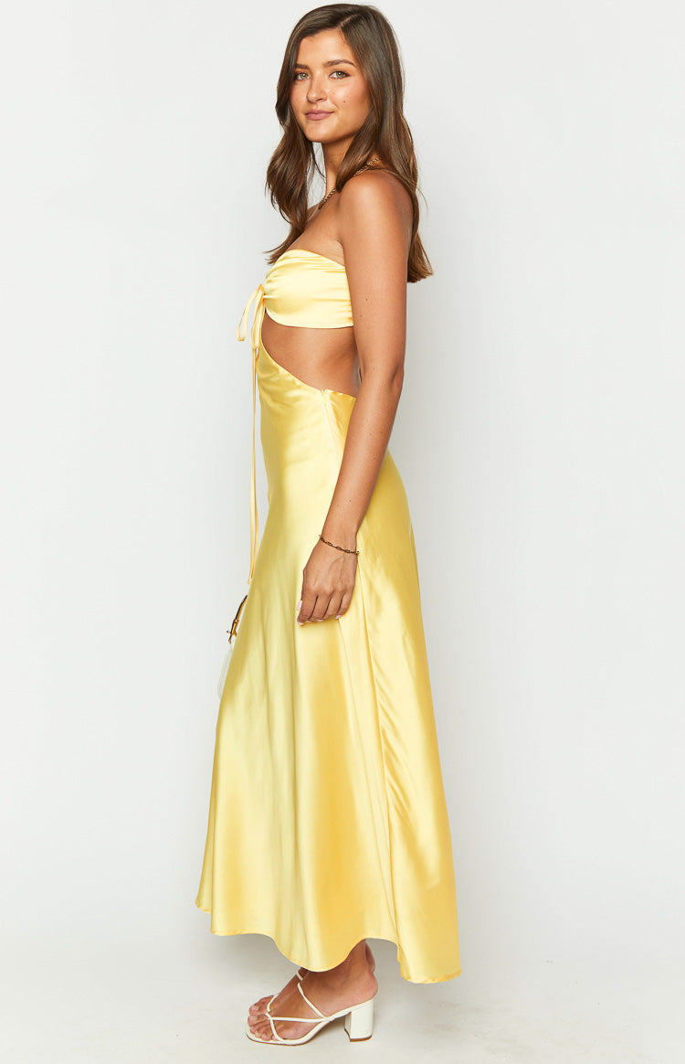 Side view of a yellow satin strapless maxi dress with side cutouts and a tie-front bust