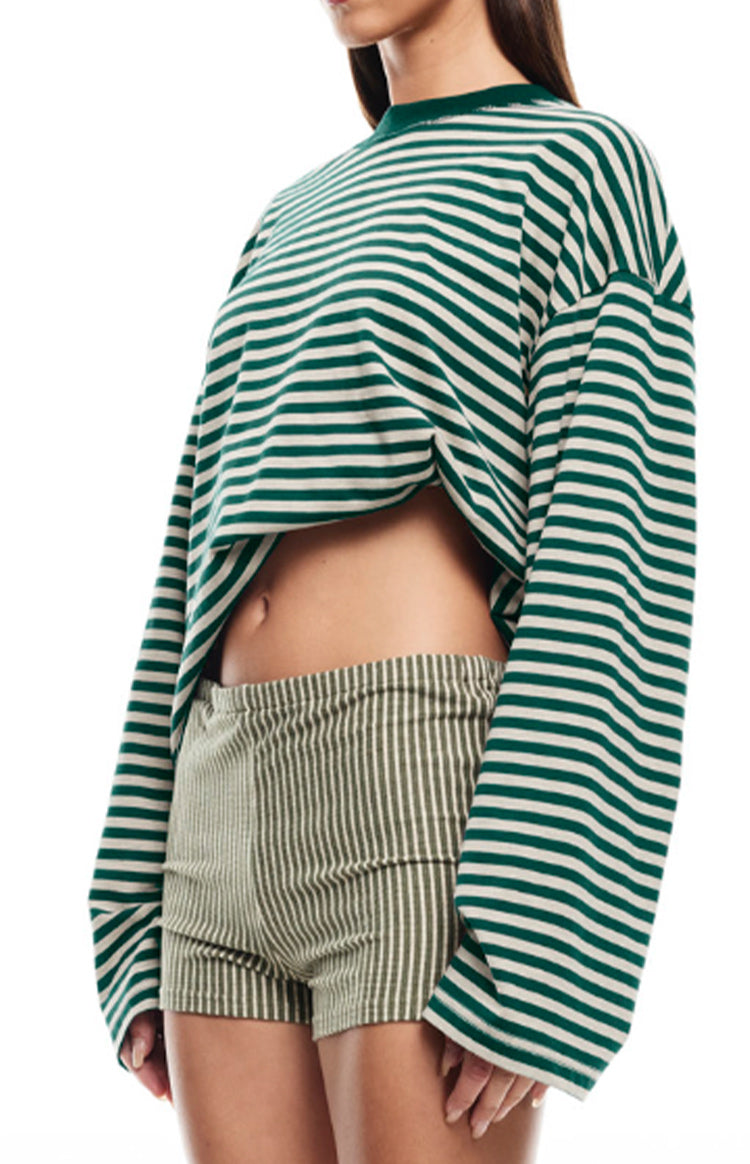 Side view of a green and white striped long sleeve top with a cropped, oversized fit