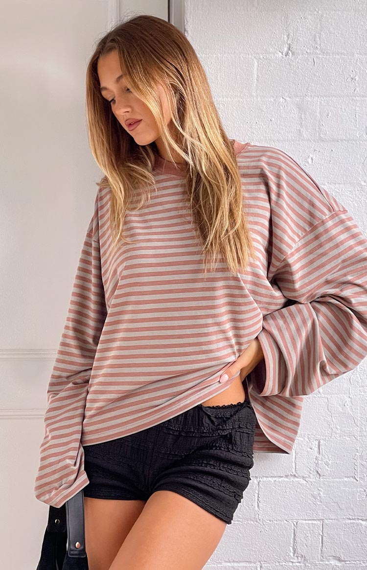 Side view showing the relaxed fit and wide sleeves of a muted pastel stripe long sleeve top