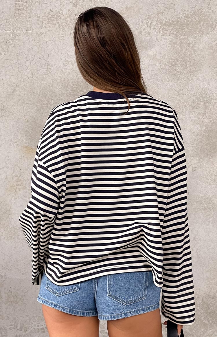 Rear view of an oversized navy and white striped long sleeve top with a crew neck and dropped shoulders