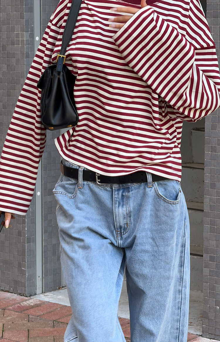 Close-up of the loose-fitting wine and white striped long sleeve top with a ribbed hem and cuff
