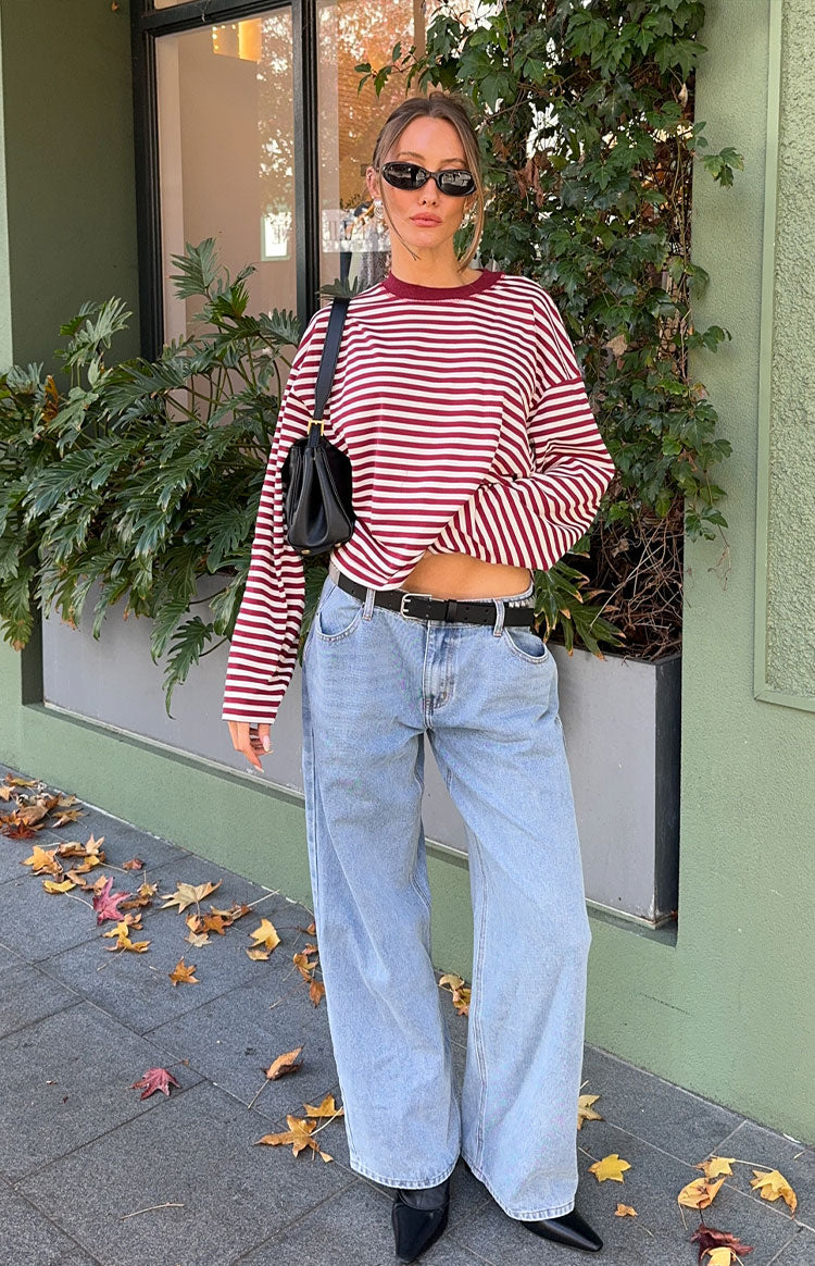 Front view of an oversized wine red and white striped long sleeve top with a crew neck and slightly cropped hem