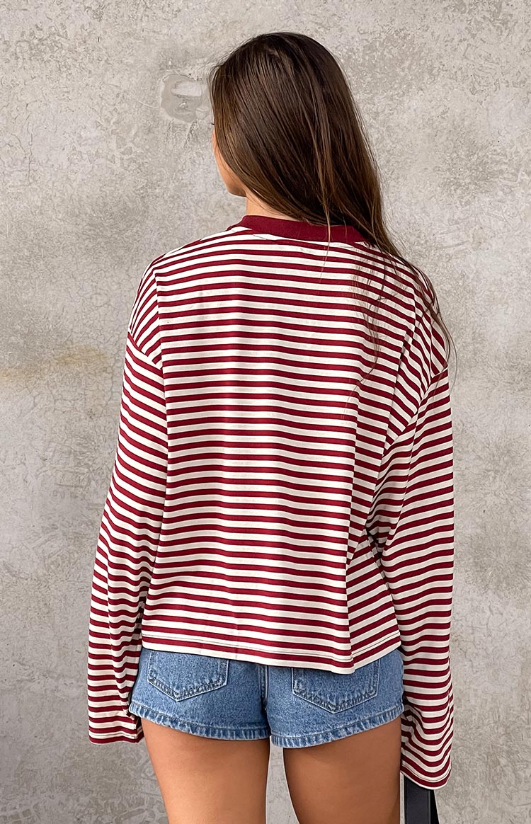 Rear view of a wine red and white striped long sleeve top with a relaxed fit and slightly cropped hem