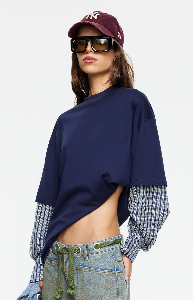 Beginning Boutique Lioness Bottega Navy Layered Contrast Sleeve Shirt — navy oversized crew neck shirt with blue plaid long sleeves and an asymmetrical cropped hem