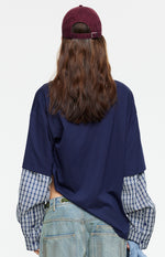 Rear view of the navy oversized shirt with blue and white plaid layered long sleeves