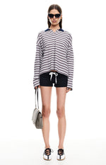 Front view of black relaxed fit shorts with a prominent white drawstring at the waist