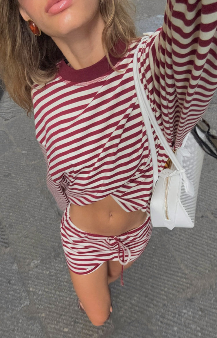 Top-down view of wine and white striped bloomers with a drawstring waist and curved hem