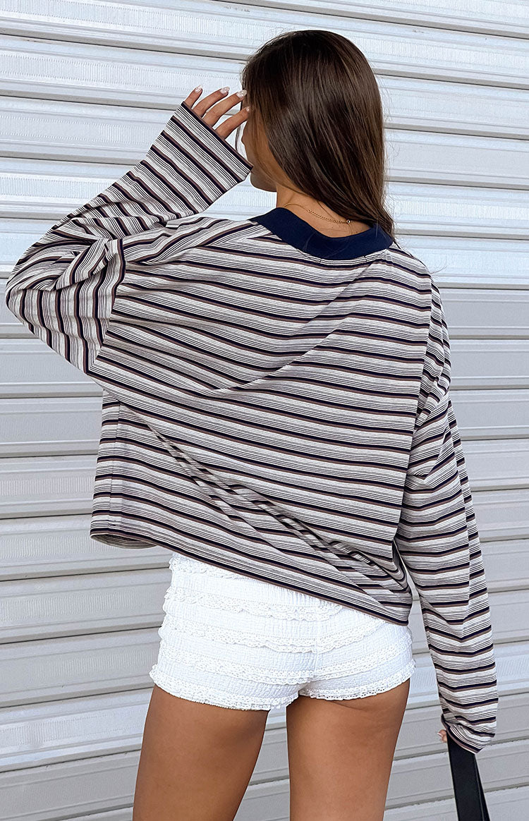 Rear view of a black, white, and burgundy striped long-sleeve jersey top with a navy collar