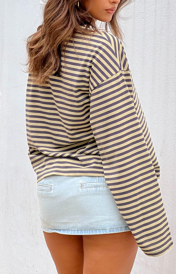 Back view of a light blue denim mini skirt with two rectangular back pockets and a subtle raw hem