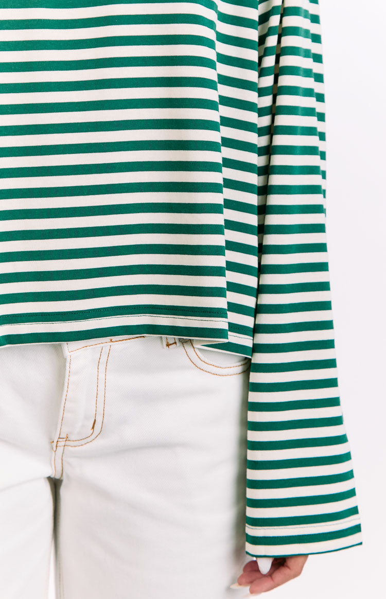 Close-up of the ribbed knit green and white striped long sleeve top's hem and cuff