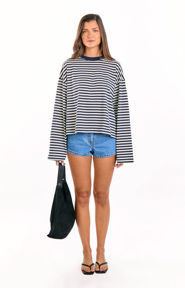 Front view of a navy and cream striped long sleeve top with an oversized fit and wide sleeves