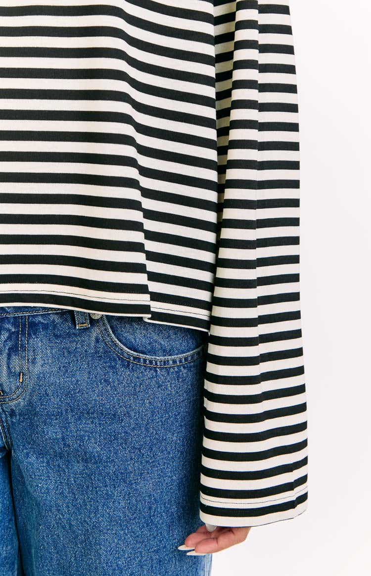 Close-up of the black and white striped long sleeve top showing the cropped hem and straight cut sleeve