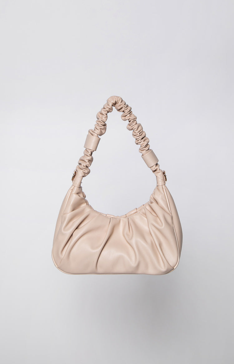 Cream handbag with a soft, gathered body and a ruched shoulder strap