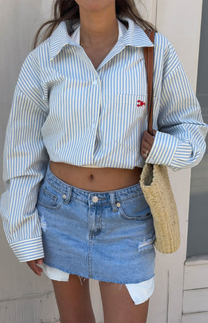 Cropped blue and white striped button-up shirt with a red embroidered lobster on the chest pocket