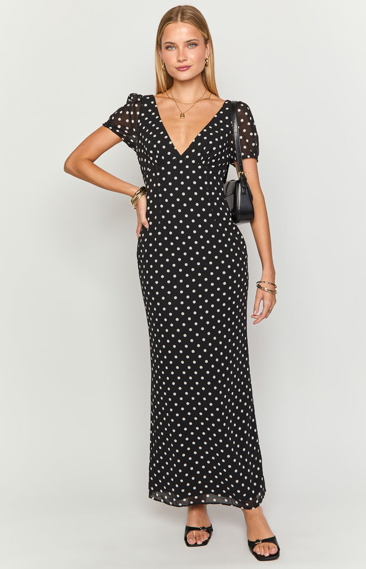 Black polka dot maxi dress featuring a deep V-neckline, sheer short puff sleeves, and a flowing skirt