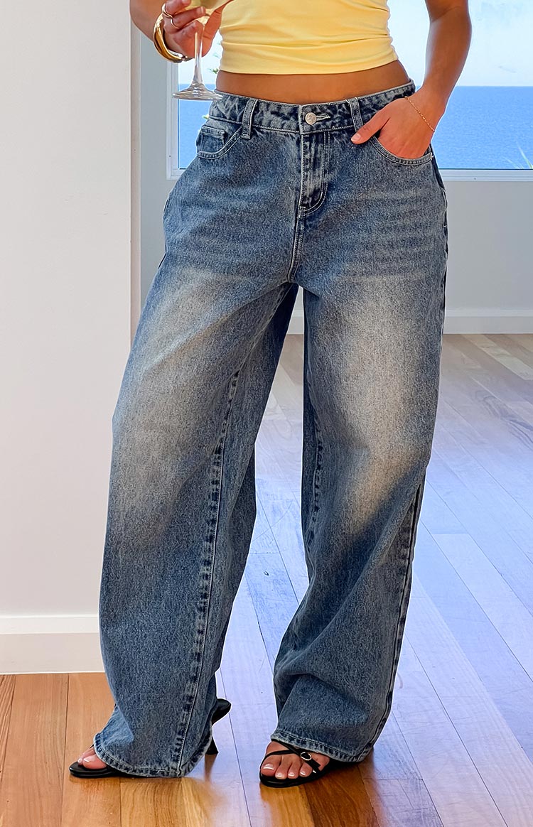 Front view of mid wash denim slouchy wide-leg jeans with visible front pockets