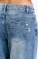 Rear view of mid wash denim slouchy jeans with heart-shaped back pockets and a relaxed wide-leg fit