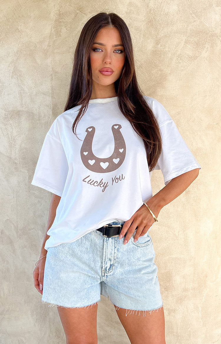 White oversized short sleeve tee featuring a brown western horseshoe graphic with 'Lucky You' text