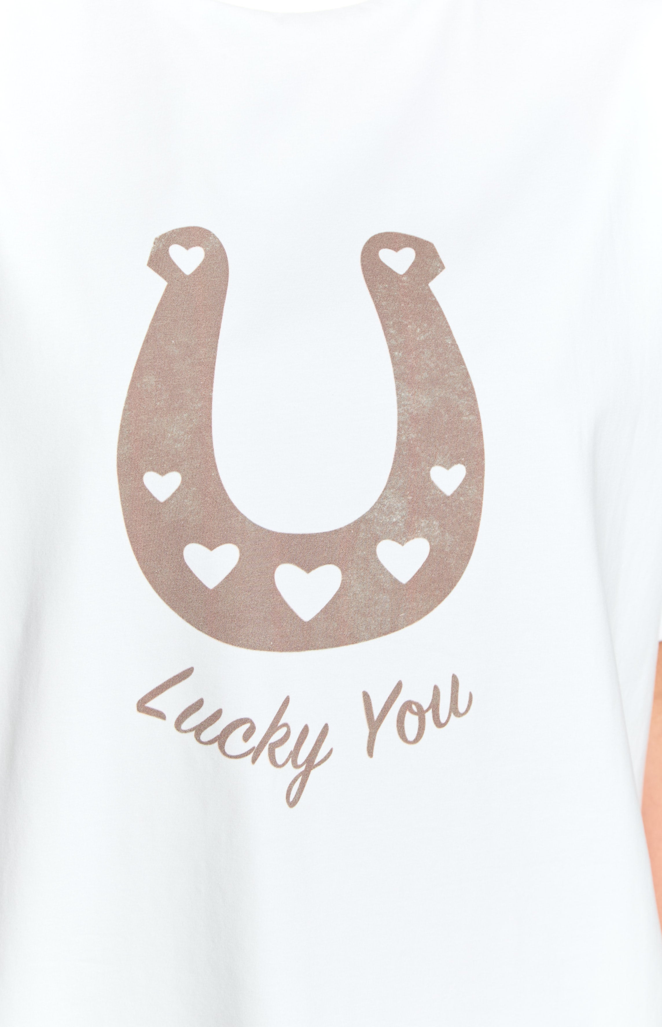 Close-up of the distressed brown horseshoe graphic with heart cutouts and 'Lucky You' text on a white tee