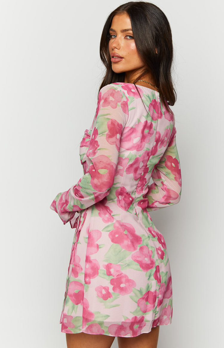 Side view of a pink floral print long sleeve mini dress with a fitted bodice and sheer overlay
