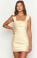 blonde girl wearing a yellow open back mini semi formal dress with gold jewellery