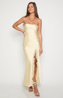 brunette model wearing yellow satin strapless maxi dress with leg split and ruffle detail