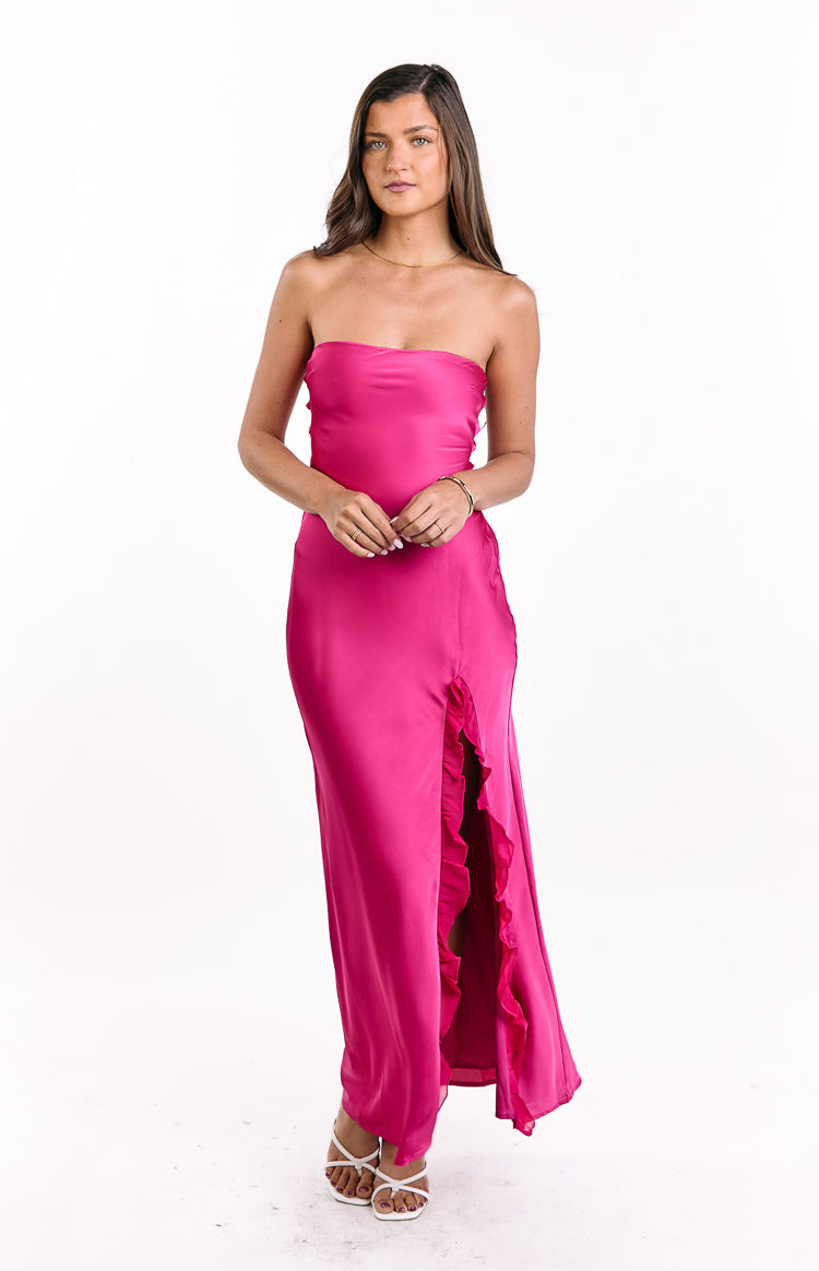 Front view of a hot pink satin strapless maxi dress with a ruffled high leg slit