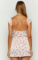 Rear view of a pink satin tulip print top with a low scoop back, tie closure, and short flutter sleeves
