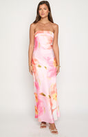 blonde model wearing a pink floral print satin formal gown with orange yellow and green flower details