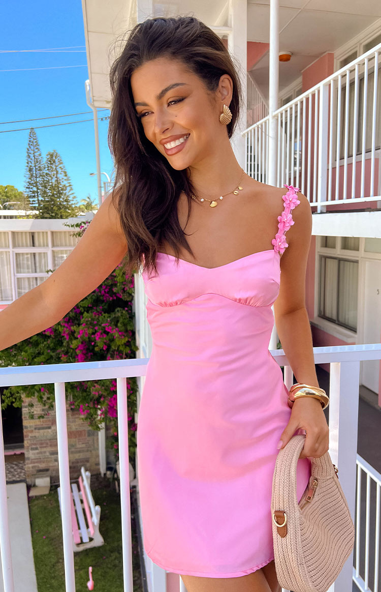 Close-up of the hot pink satin mini dress showing the sweetheart neckline and delicate floral detail on the shoulder strap
