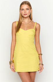 Front view of a bright yellow mini dress with a sweetheart neckline and daisy-embellished straps