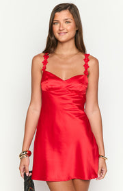 Close-up of the red satin mini dress showing the sweetheart neckline and floral embellished spaghetti straps