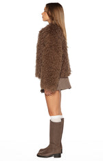 Side view of a brown shaggy fur jacket with a relaxed, cropped fit
