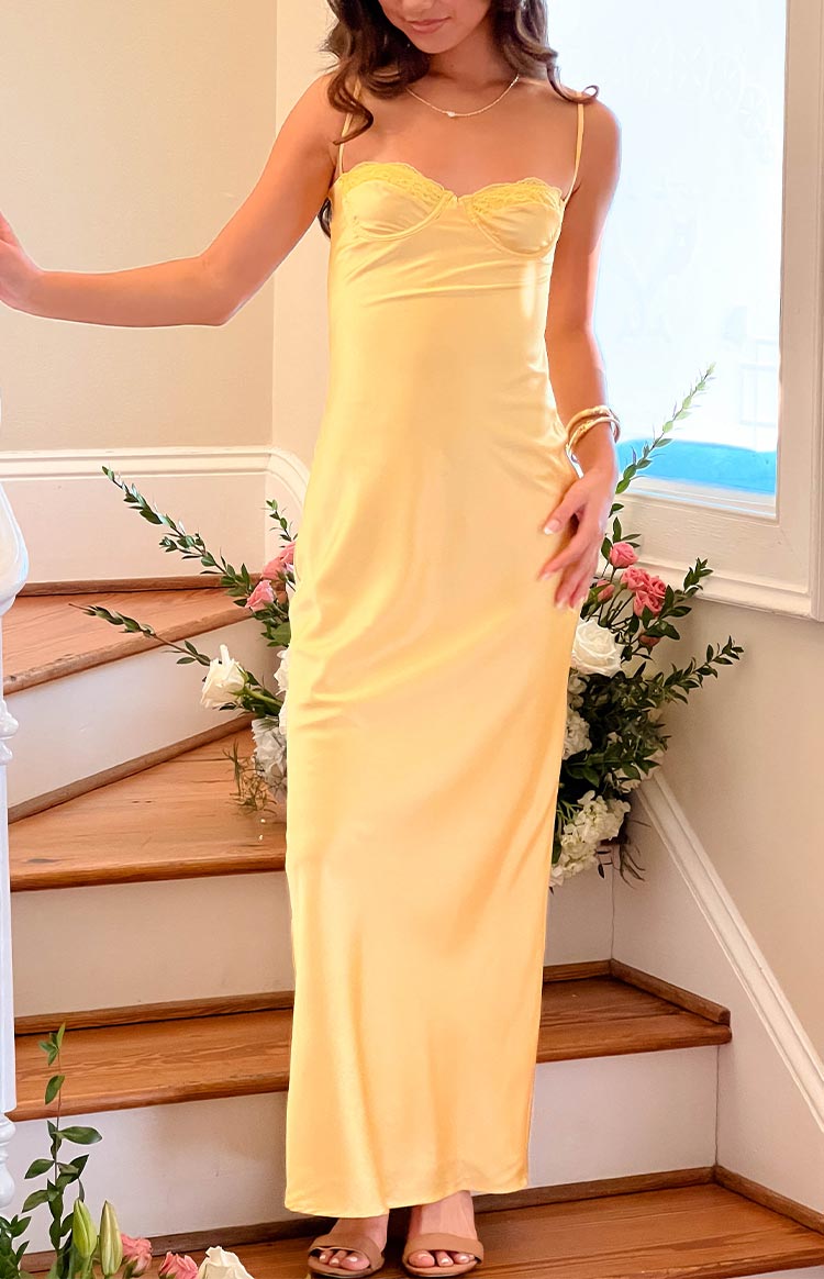Full length view of the yellow satin midi dress, highlighting its delicate lace bust and elegant, flowing silhouette