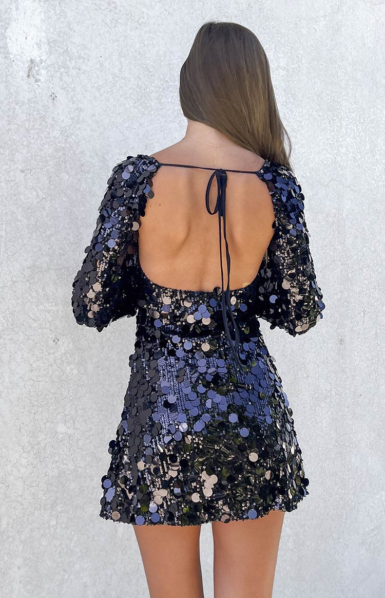 Back view of a black sequin mini dress showing the deep scoop back and neck tie detail