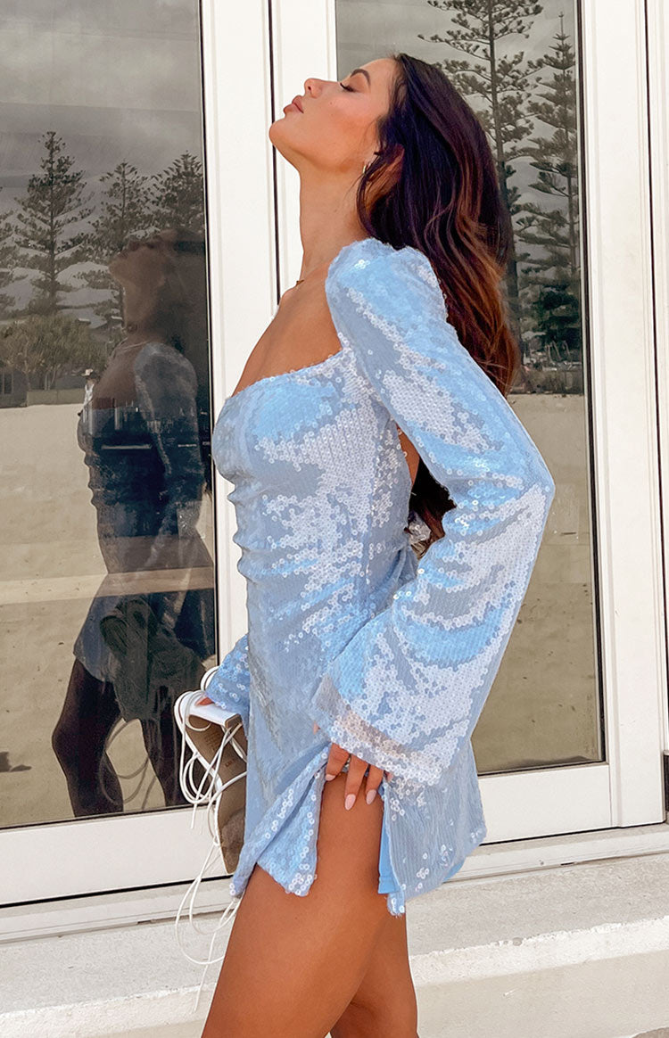 Side view of a blue sequin mini dress with long sleeves, a square neckline, and a high side slit